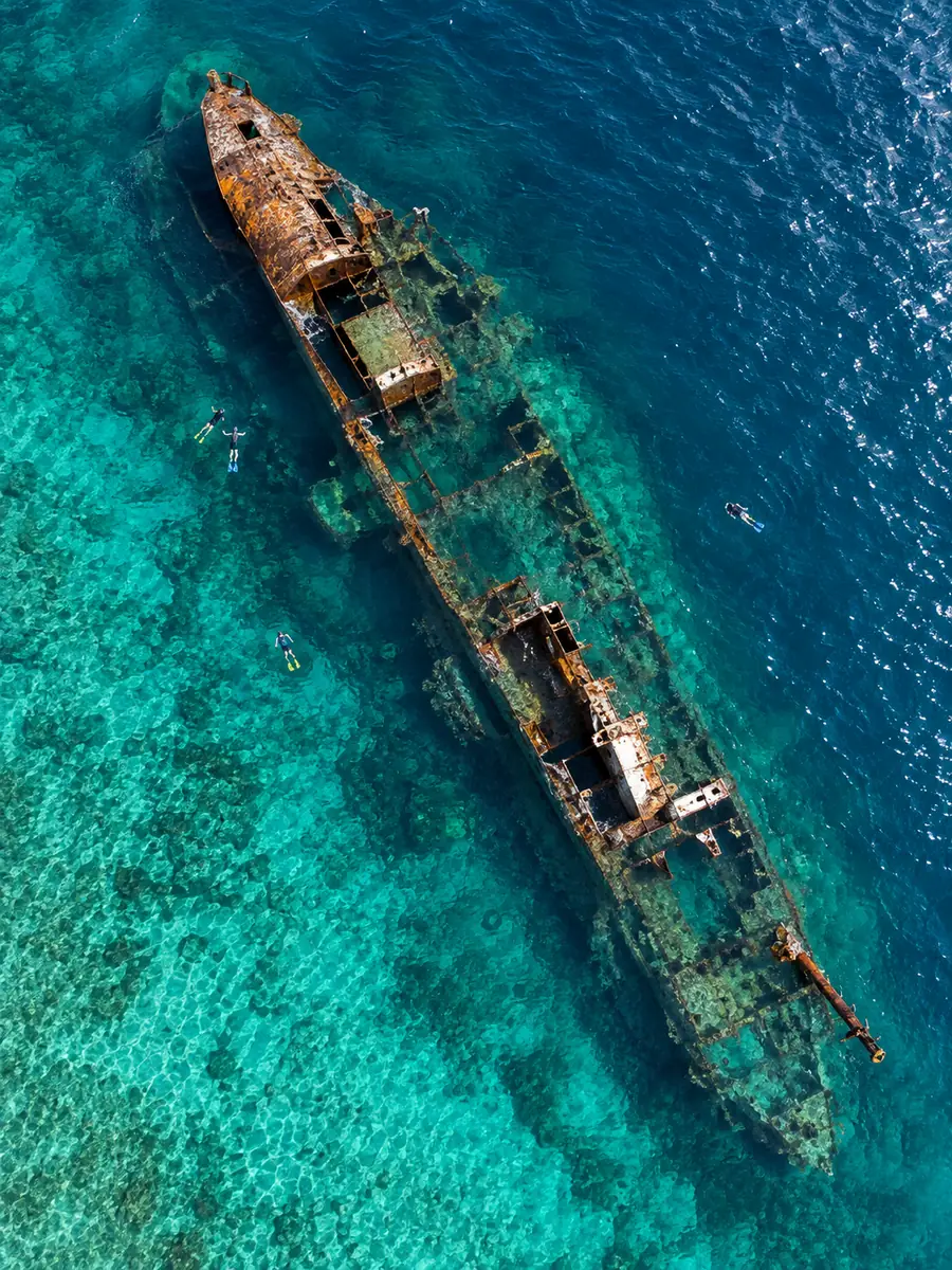 Vista aérea de un naufragio oxidado bajo aguas turquesas