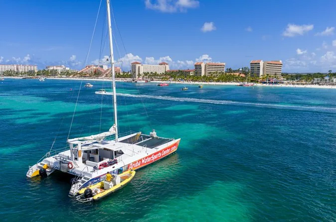 Ein weißer Katamaran vor Anker im türkisfarbenen Wasser vor Palm Beach